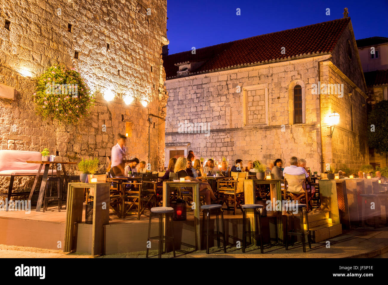 Notte e i ristoranti della Città Vecchia che costeggiano il lungomare di Zakerjan sulla cima del Muro della Città Est nella città vecchia di Korcula, Croazia Foto Stock