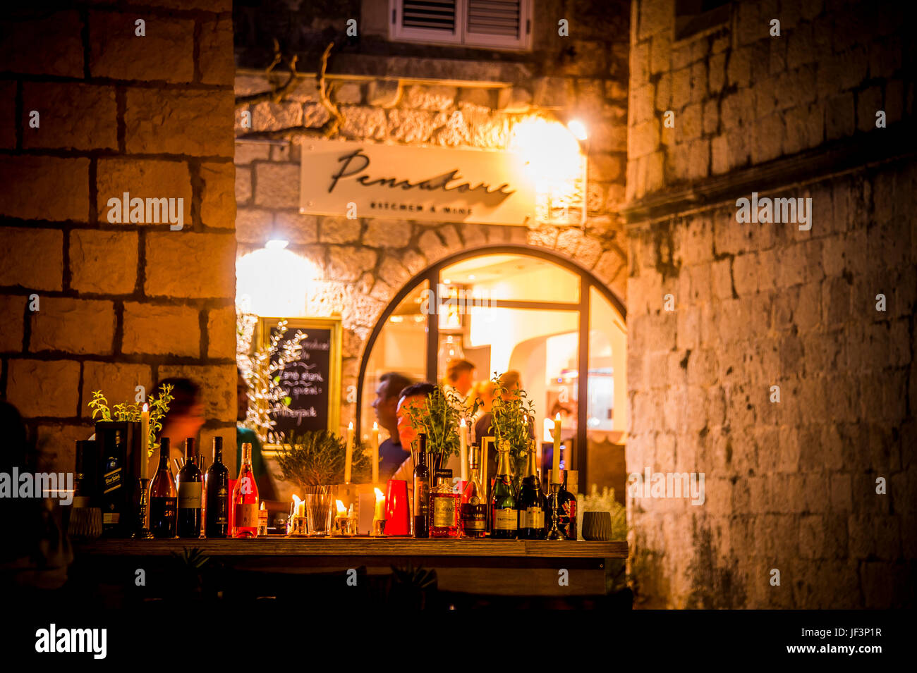 Notte e i ristoranti della Città Vecchia che costeggiano il lungomare di Zakerjan sulla cima del Muro della Città Est nella città vecchia di Korcula, Croazia Foto Stock