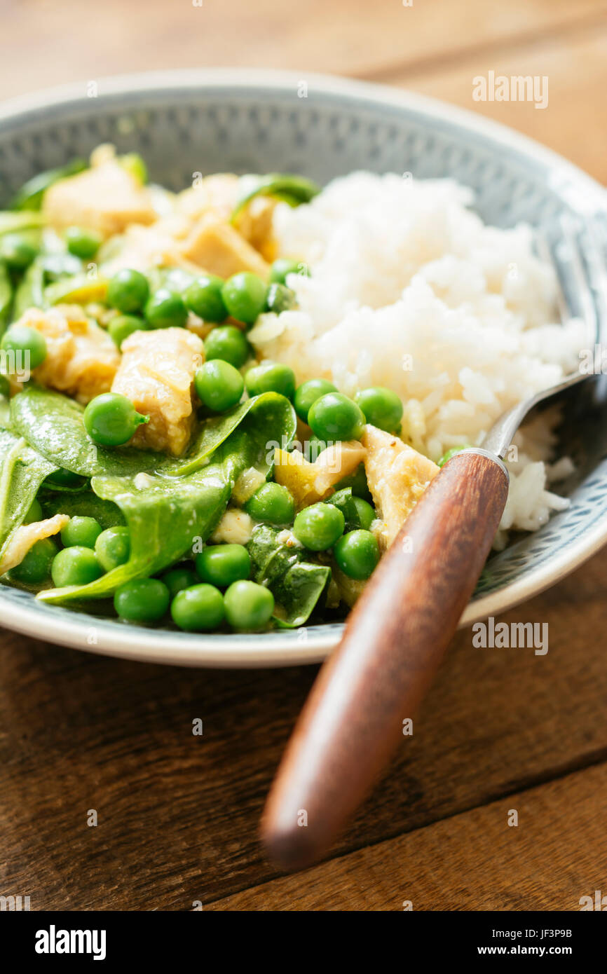 Vegan curry verde tailandese con la proteina di soia, spinaci e fresco giardino piselli Foto Stock