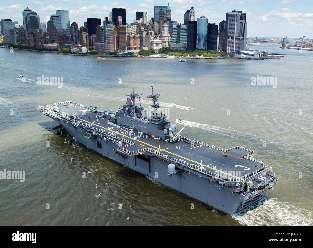 Marinai e Marines uomo le rotaie e compitare "Io amo New York' sul ponte di volo dell'assalto anfibio nave USS Kearsarge (LHD 3) come la nave entra nel porto di New York. DoD foto di Sottufficiali di prima classe Aaron Glover, U.S. Navy. Foto Stock