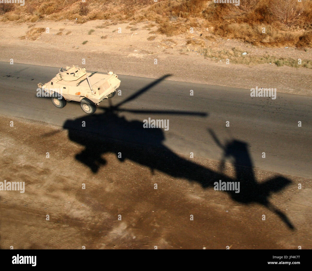 Fly esercito! Foto di Dipartimento dell'esercito Gennaio 09, 2007 l'ombra di un AH-64 elicottero Apache è un promemoria per ricordare che questo convoglio in Iraq è ben protetto. Argomenti correlati: Fly esercito! Foto Stock