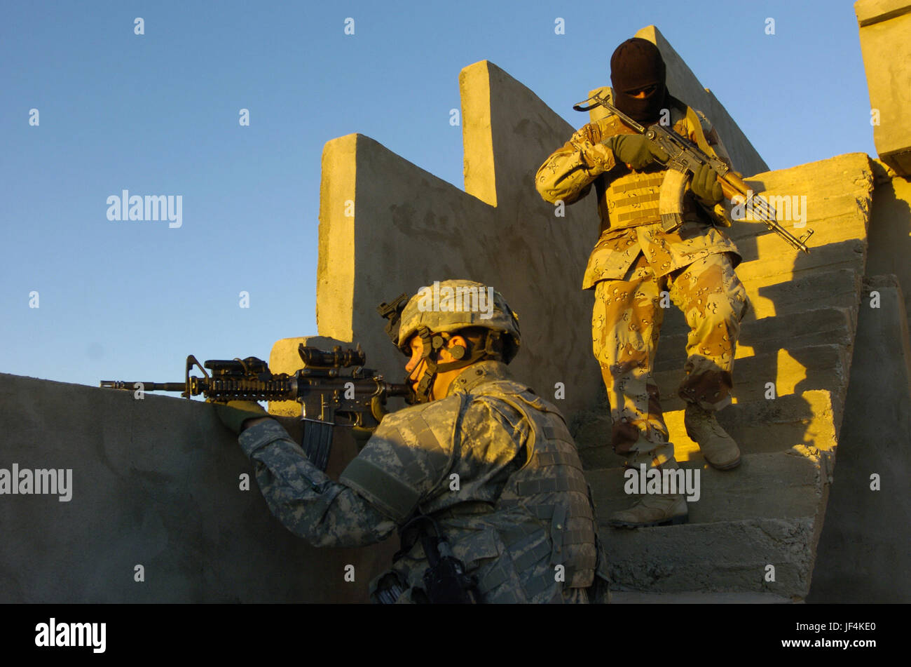 061111-A-2519G-124 U.S. Il personale dell'esercito Sgt. Burkman Coriey e un esercito iracheno soldato cancella il tetto di una casa iracheno durante un cordone e operazione di ricerca in Hawijah, Iraq, su nov. 11, 2006. I soldati sono alla ricerca di ribelli, non autorizzati di armi e materiali per la costruzione di ordigni esplosivi artigianali. Burkman è attaccato alla Società Delta, 2° Battaglione, 27° Reggimento di Fanteria. DoD foto di Sgt. 1. Classe Michael Guillory, U.S. Esercito. (Rilasciato) Foto Stock