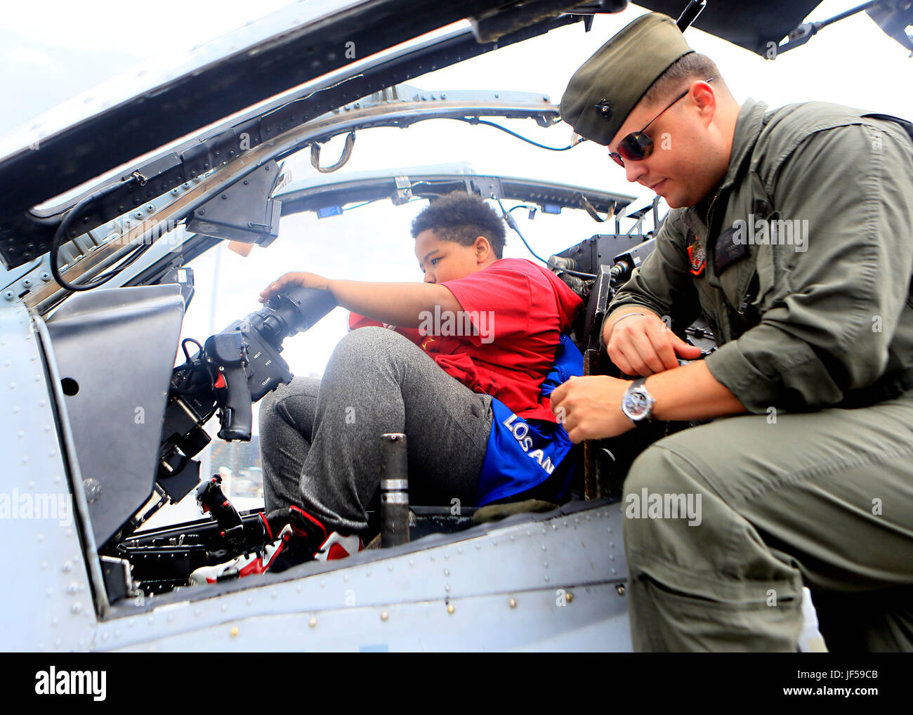 Un bambino si trova all'interno della cabina di pilotaggio di un AH-1W Super elicottero Cobra durante un tour a bordo della USS Kearsarge (LHD 3) come parte della flotta settimana New York 2017, 27 maggio 2017. Marines, marinai e la costa guardie chaperoned 20 bambini partecipanti alla undicesima edizione del Progetto Speranza. (U.S. Marine Corps foto di Sgt. Gabby Petticrew) Foto Stock