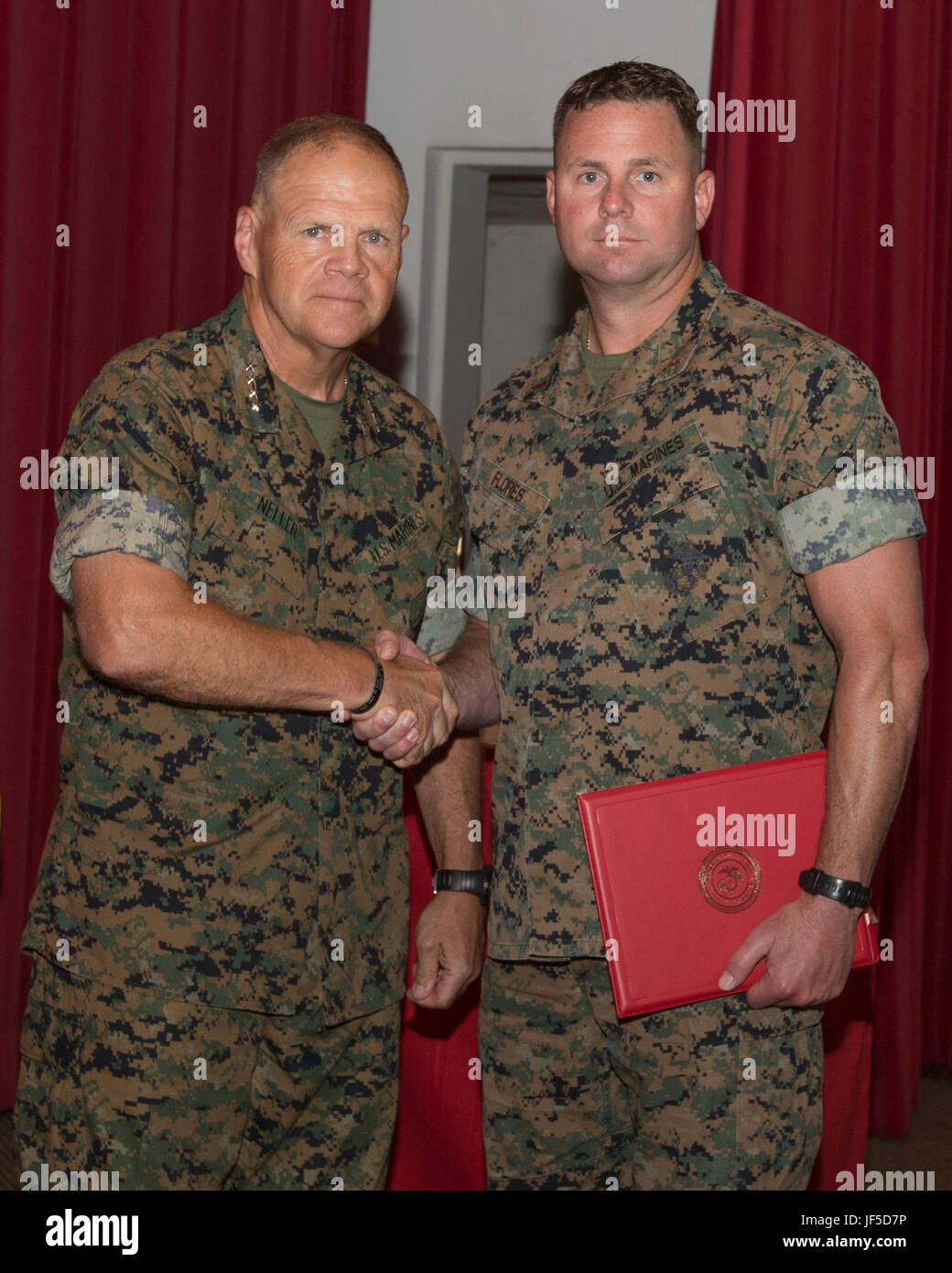 Il comandante del Marine Corps gen. Robert B. Neller, sinistra stringe la mano con il Chief Warrant Officer 3 Sean Flores durante il comandante dell'innovazione Symposium 2017 Cerimonia di premiazione al Marine Corps base Quantico, Virginia, 31 maggio 2017. Flores è stato premiato per le sue idee sul miglioramento della formazione e dell'istruzione per migliorare le capacità decisionali di piccoli capi unità. (U.S. Marine Corps foto di Cpl. Samantha K. Braun) Foto Stock