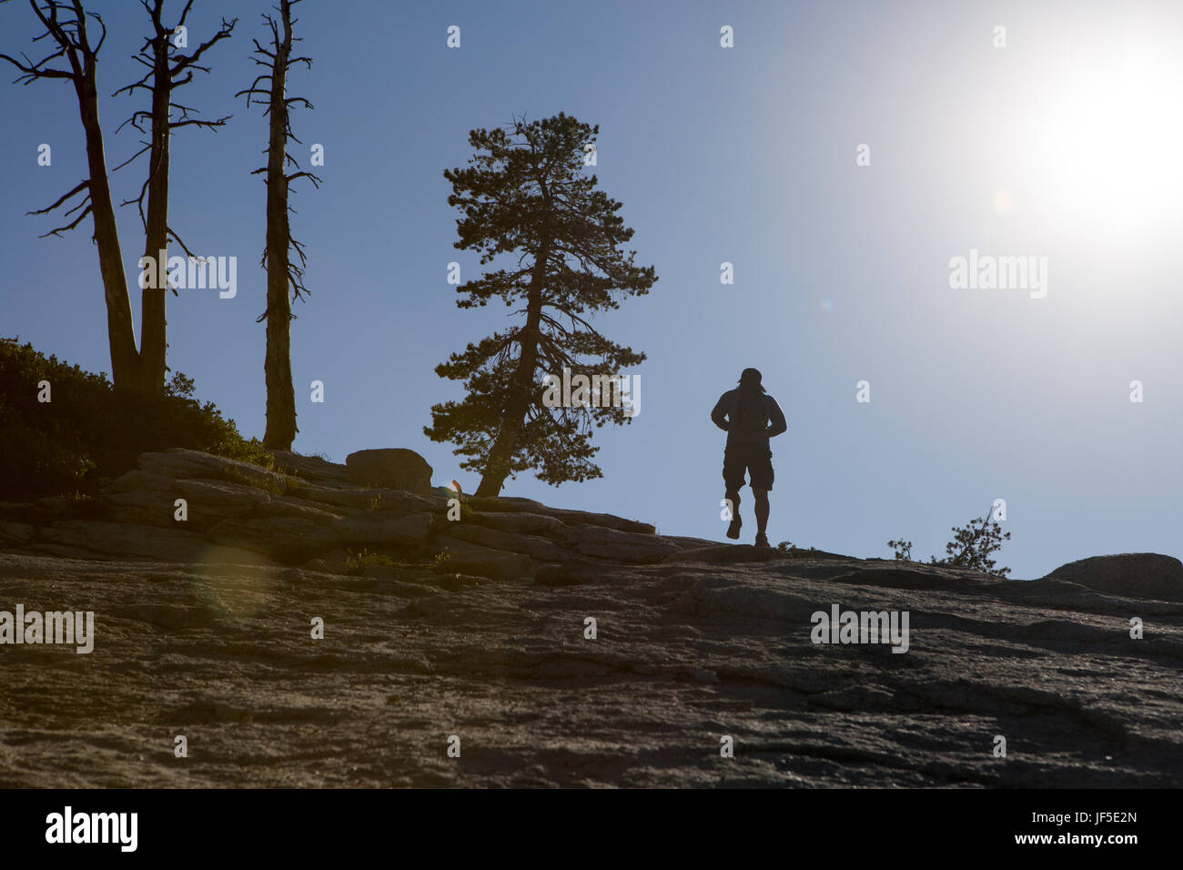 Un escursionista sale il sentiero roccioso che conduce alla cupola sentinella, un picco roccioso che offre splendide vedute sulla valle di Yosemite. Foto Stock