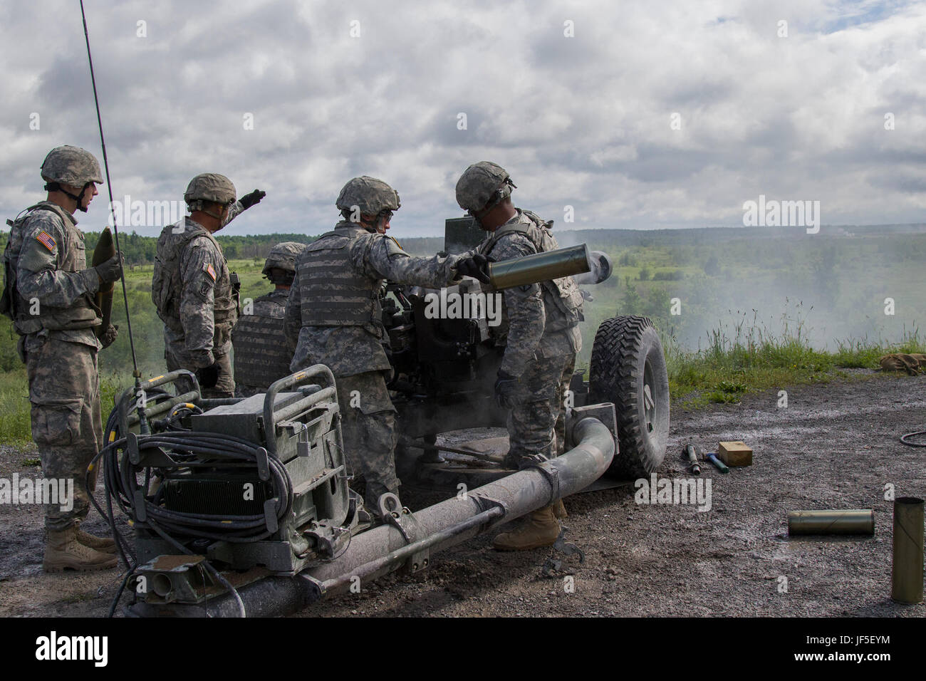 Stati Uniti Soldati con Charlie batteria, 1° Battaglione, 101st campo reggimento di artiglieria, 86a brigata di fanteria combattere Team (montagna), Massachusetts National Guard, cancellare un guscio vuoto da un M119A3 105 mm obice a Fort Drum, N.Y., 20 giugno 2017. Il battaglione condotta artiglieria campo live esercitazioni antincendio durante la loro formazione annuale per mantenere la disponibilità. (U.S. Esercito nazionale Guard foto di Spc. Avery Cunningham) Foto Stock