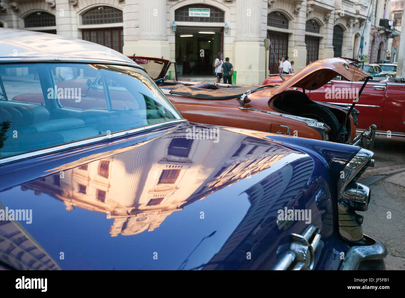 L'architettura cubana nel centro di Havana è riflessa dal tronco di una classica vettura americana. Foto Stock