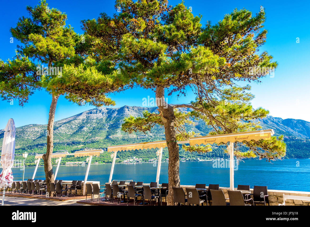 I ristoranti si trovano lungo le mura della città orientale. La vista mozzafiato sul Mar Adriatico e sulla terraferma croata si trova nella vecchia città di Korcula, in Croazia Foto Stock