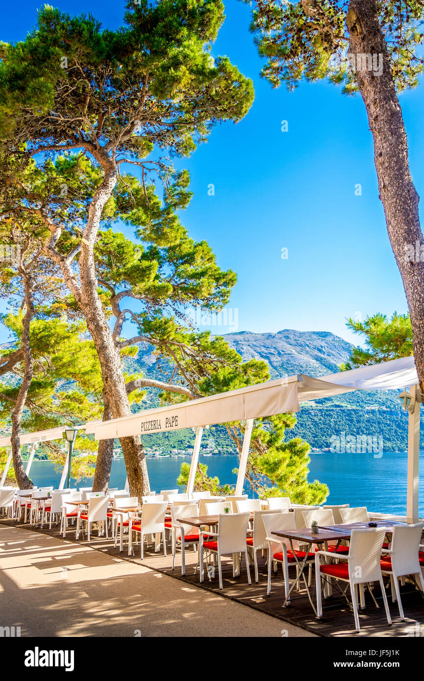 I ristoranti si trovano lungo le mura della città orientale. La vista mozzafiato sul Mar Adriatico e sulla terraferma croata si trova nella vecchia città di Korcula, in Croazia Foto Stock