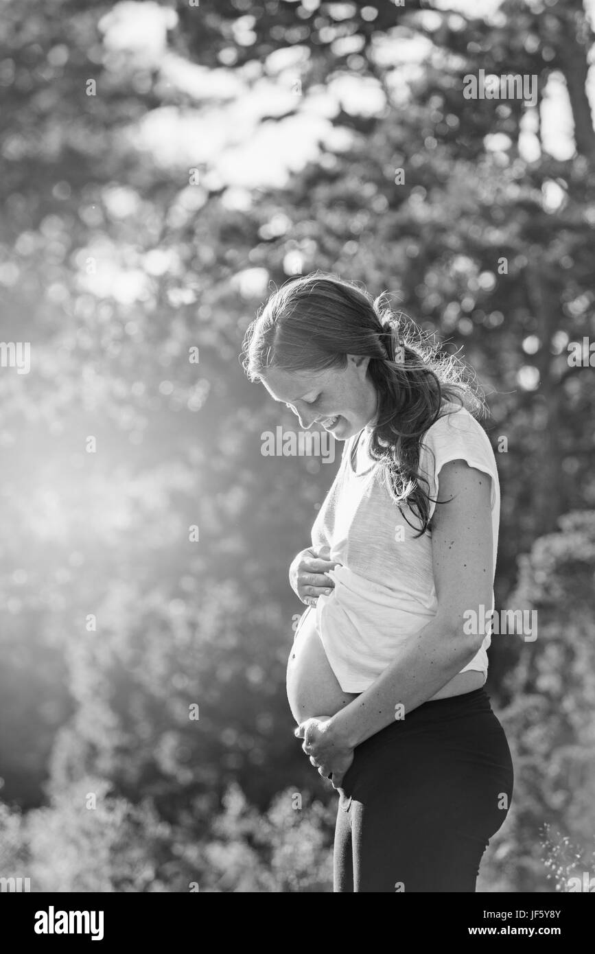 Sorridente donna in stato di gravidanza Foto Stock