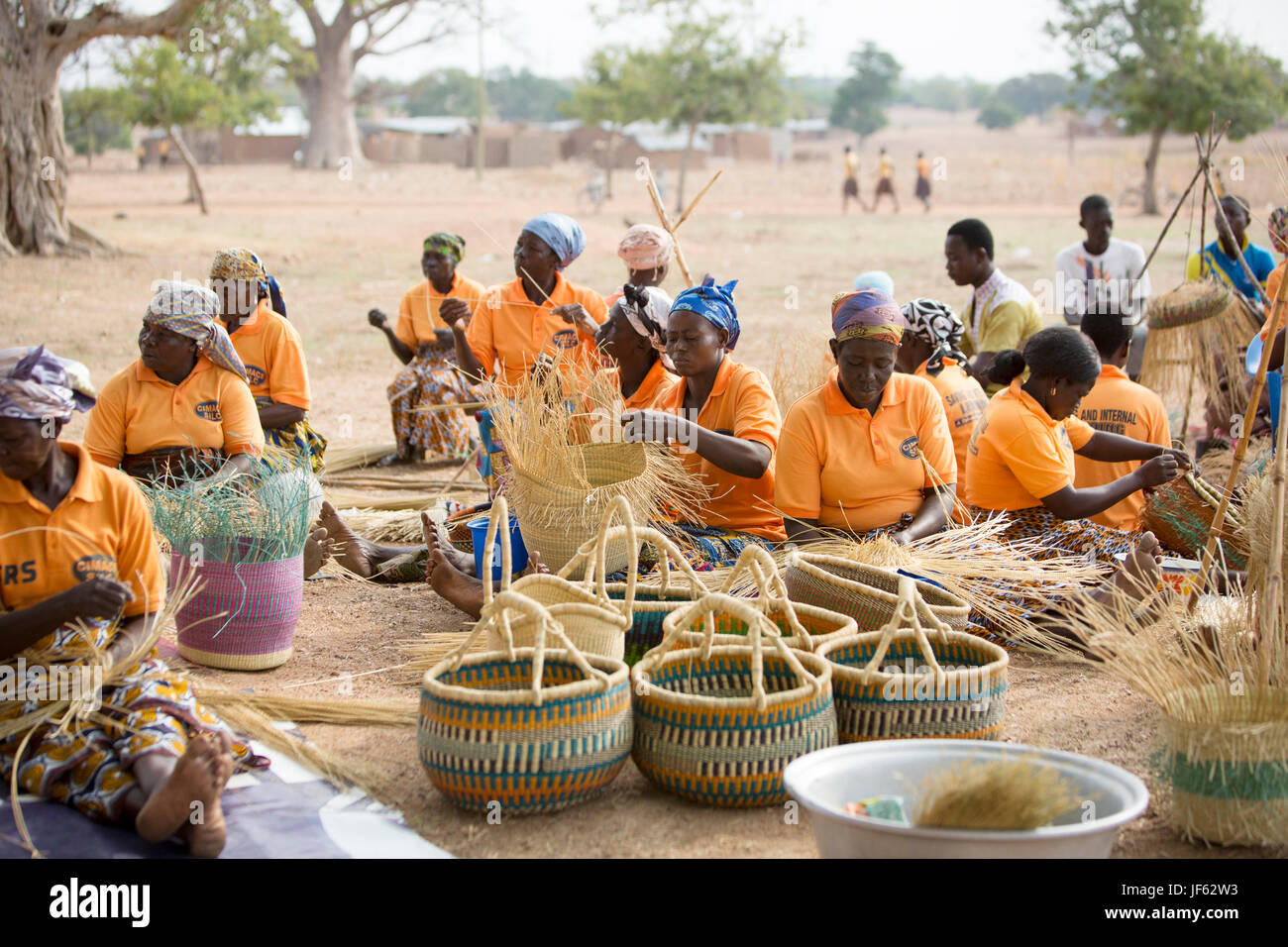 Le donne da un tessitore cooperativa tessere tradizionali cesti di paglia insieme nella Upper East Regione, Ghana. Foto Stock