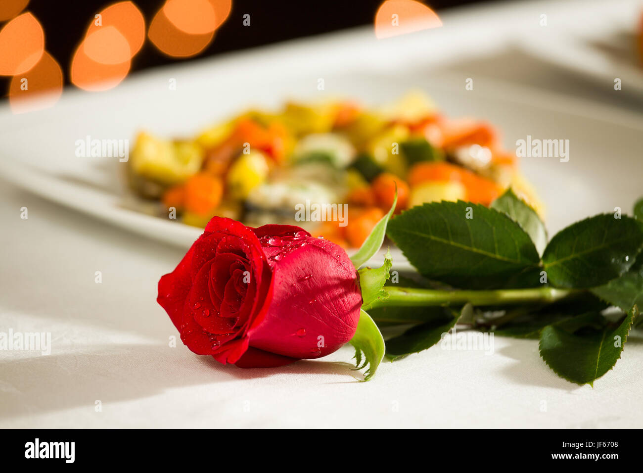 Una rosa rossa per una cena romantica Foto stock - Alamy