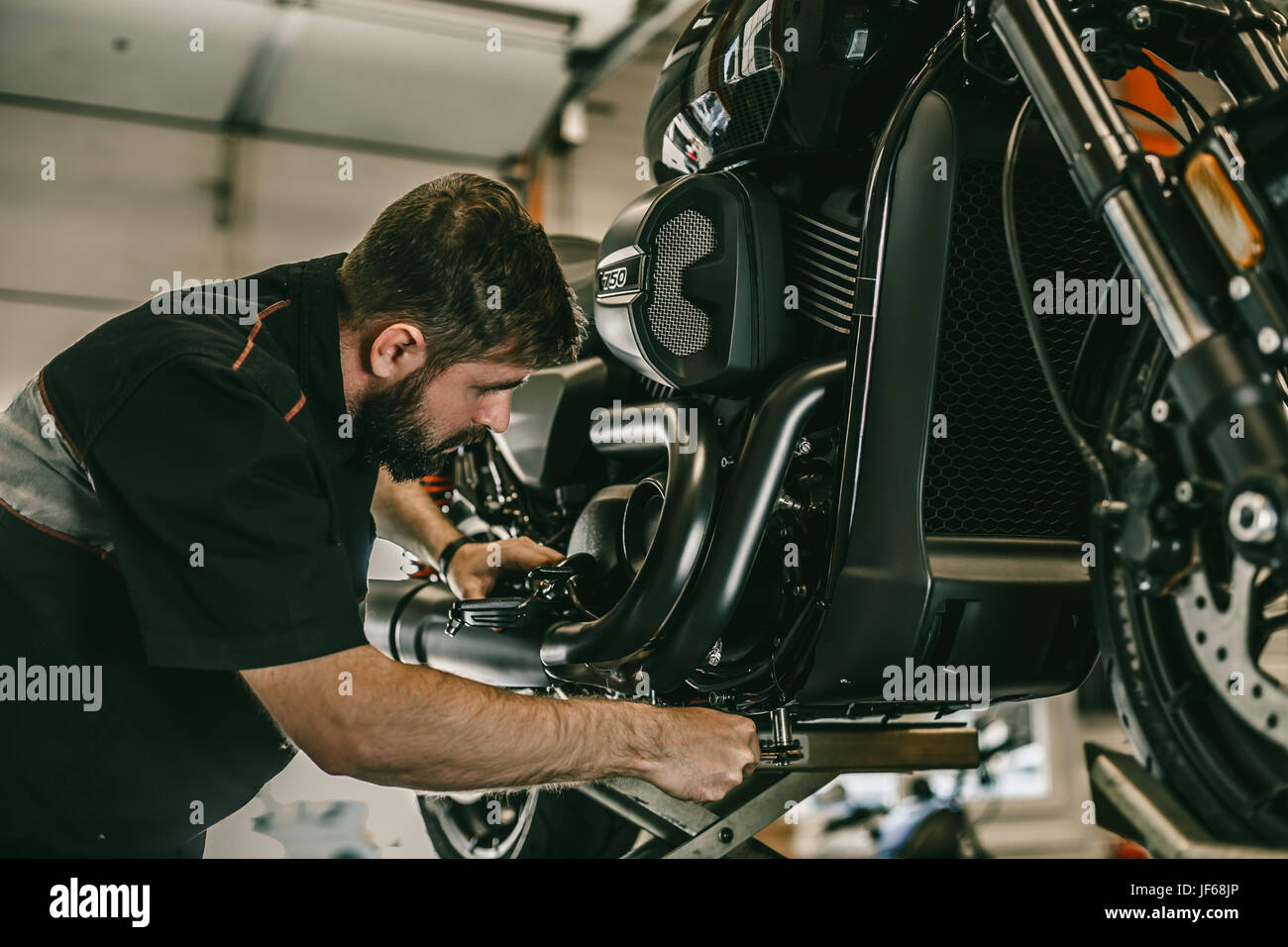 Meccanico professionista cambiare l'olio in una motocicletta. La moto sportiva è sul sollevatore. Foto Stock