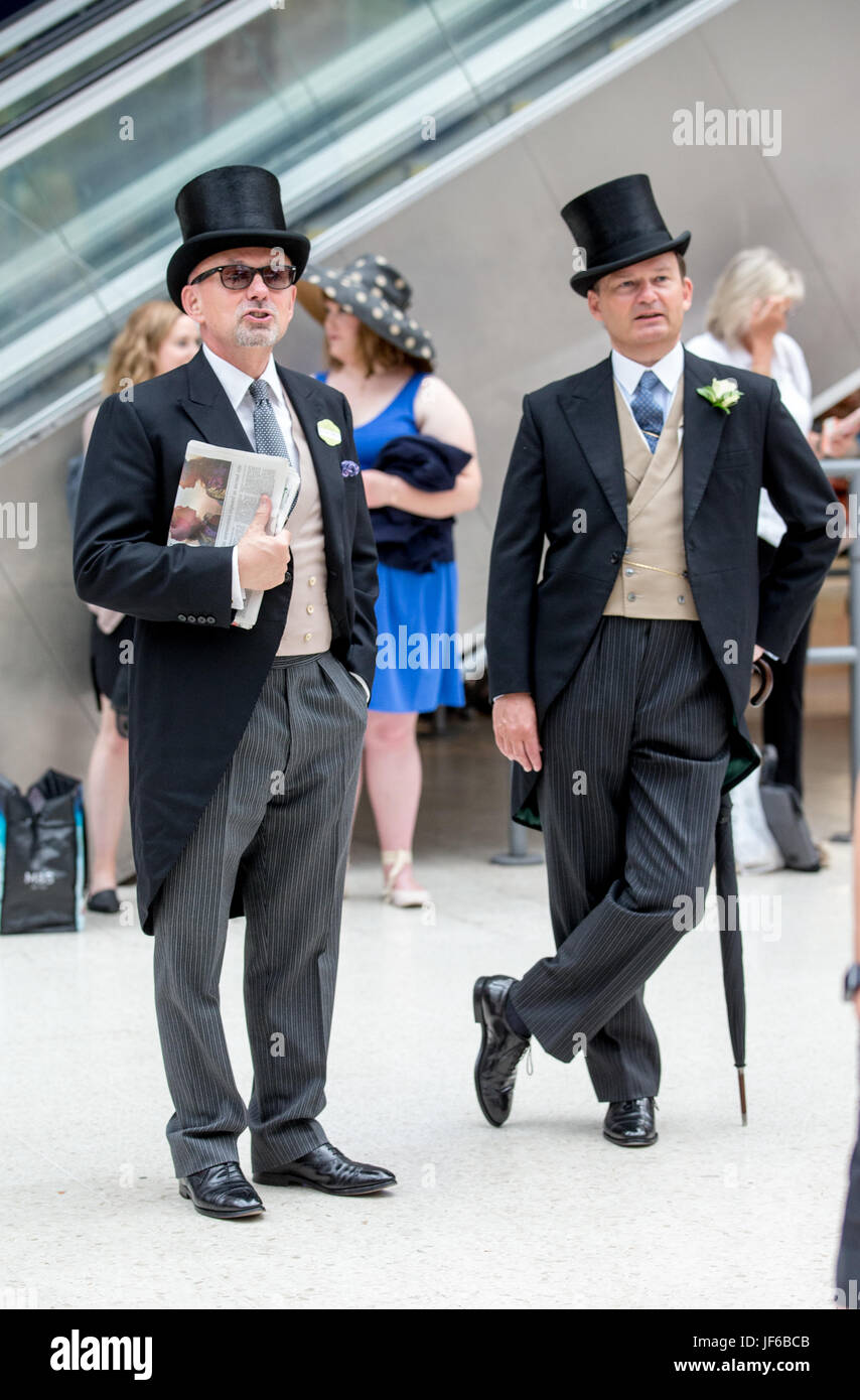 Due Racegoers a Londra Waterloo indossare top hat e code sul loro modo di Royal Ascot sul Signore giorno in attesa a bordo del treno Foto Stock