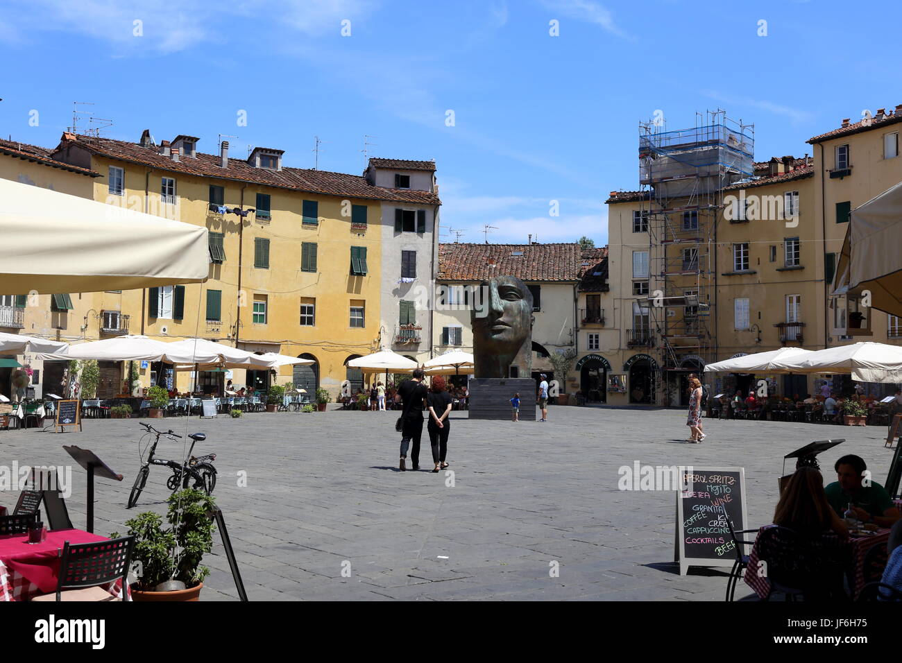 La Piazza dell' Anfiteatro di Lucca in centro città con i turisti, ristoranti e opere di Igor Mitoraj. Foto Stock