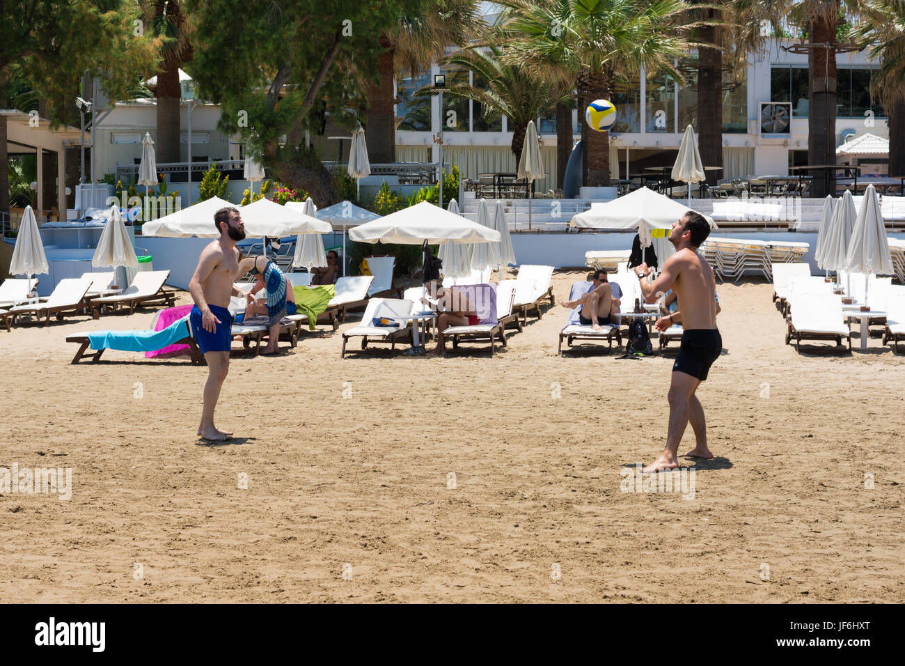Giovani uomini la riproduzione di calcio sulla spiaggia sulla spiaggia di Agia Marina, Creta, Isole Greche, Grecia Foto Stock