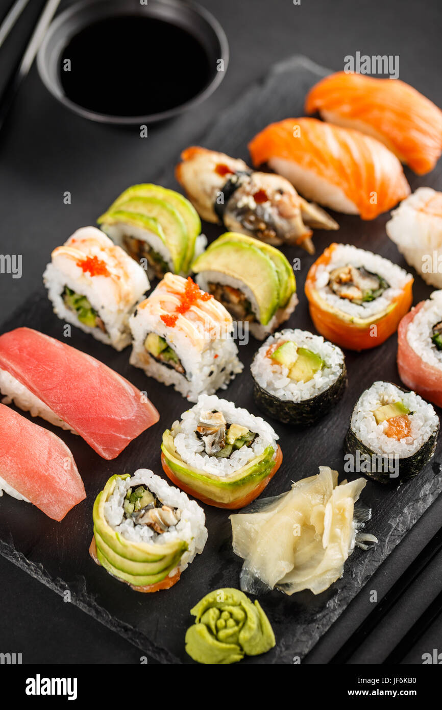 Sushi Sashimi e sushi rullo impostato con la soia su sfondo nero Foto Stock