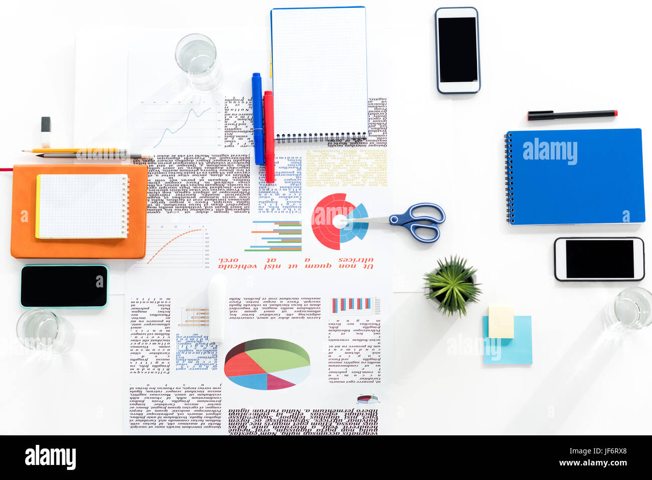 Vista dall'alto di smartphone con schermi vuoti, delle carte e delle forniture di ufficio al lavoro Foto Stock