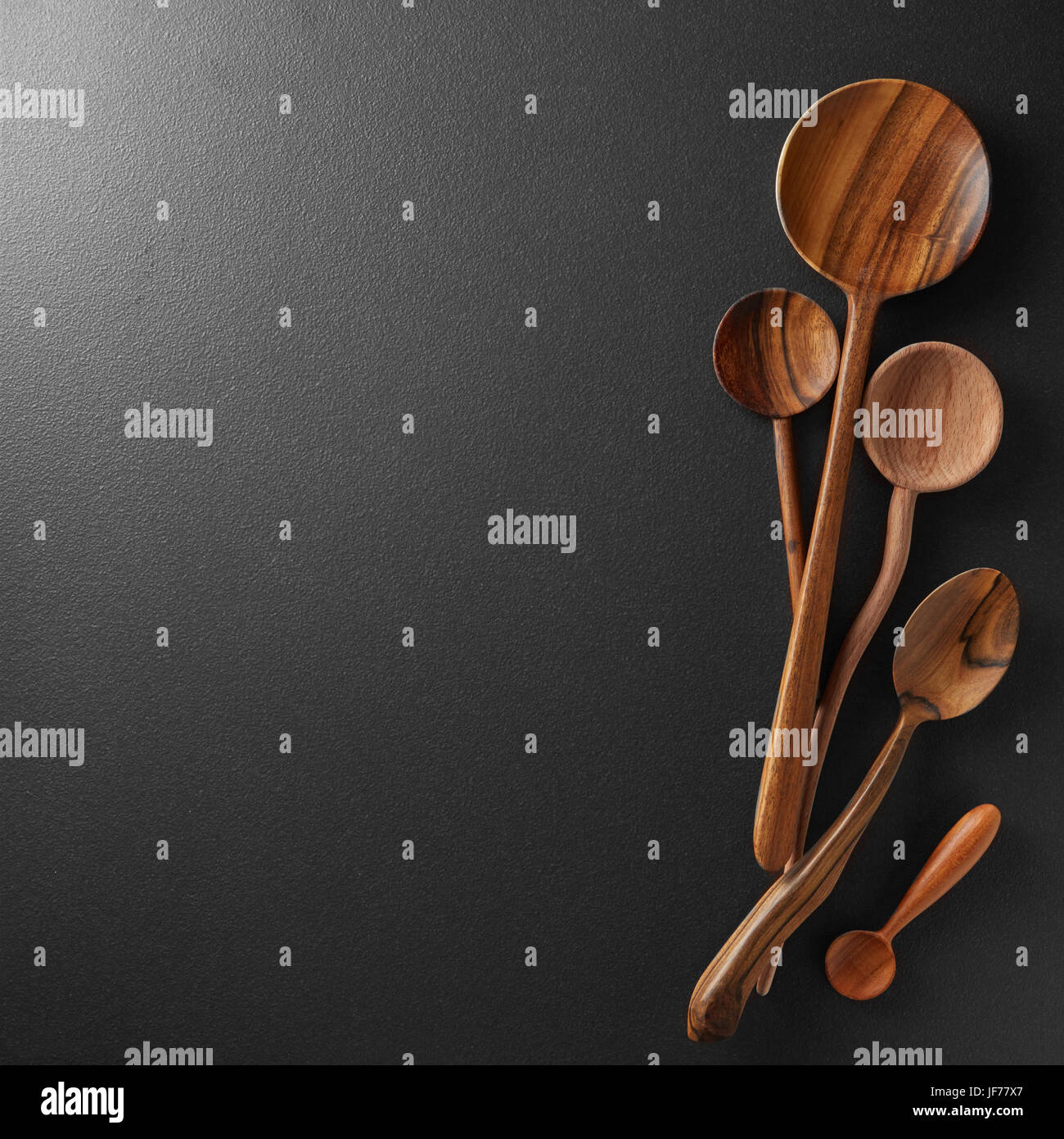 Cucchiai di legno nero su sfondo della scheda Foto Stock