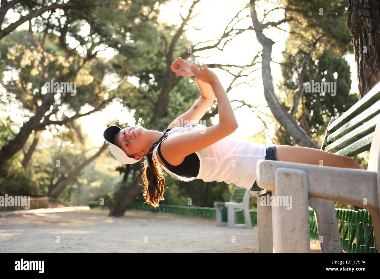 Bellezza ragazza adolescente fare esercizio sulla panchina nel parco di mattina Foto Stock