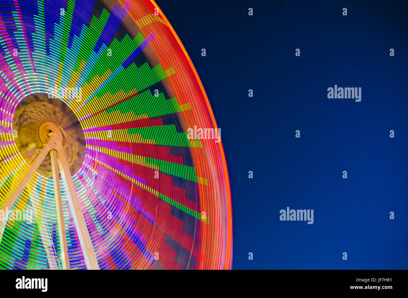 Ruota panoramica sul cielo blu, copia dello spazio. Esposizione lunga Foto Stock