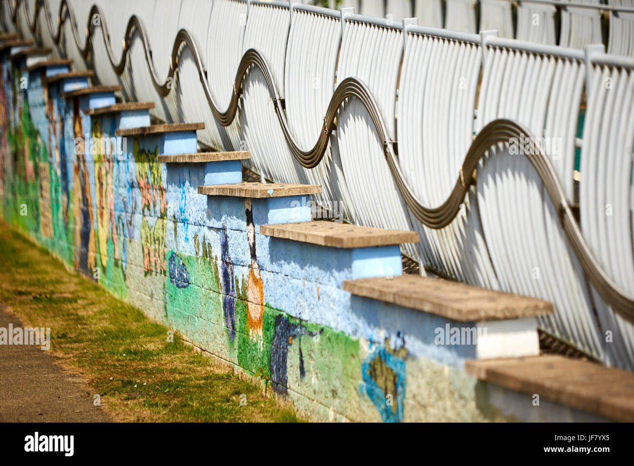 Una parete dipinta con una scena di stazionamento sotto le barriere del ponte Cutteslowe nel Parco Sunneymead Foto Stock