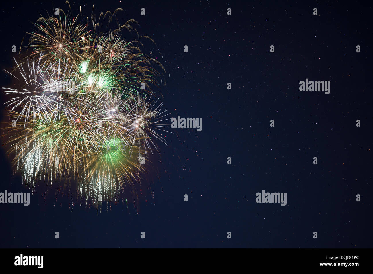 Bella verde oro celebrazione fuochi d'artificio ubicata sulla sinistra oltre il cielo notturno, copia dello spazio. Giorno di indipendenza, 4 luglio, le vacanze di Capodanno Saluto ba Foto Stock