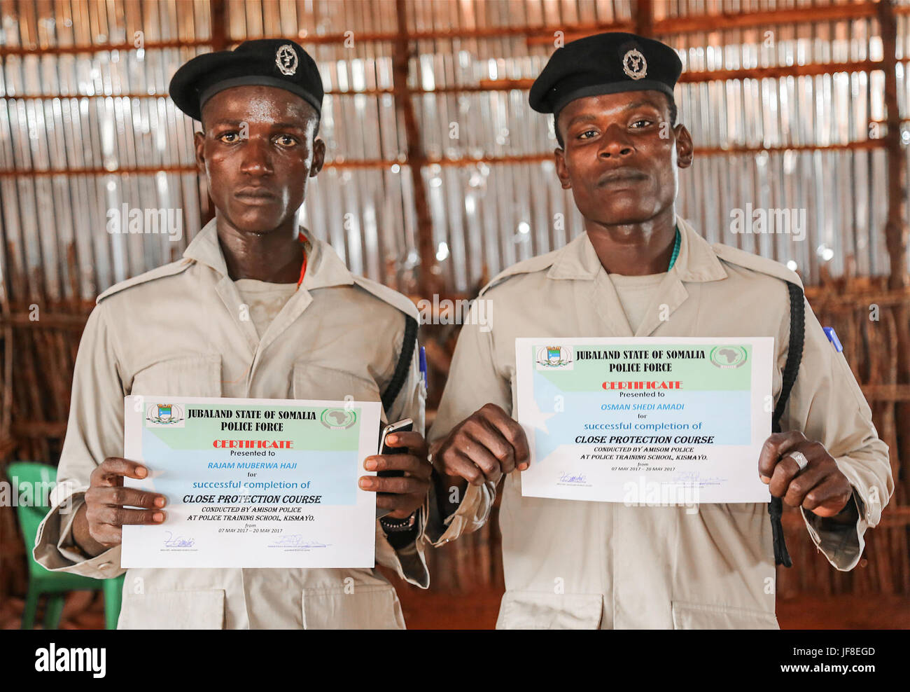 La polizia di tirocinanti tenere certificati da essi ricevuti durante una stretta protezione corso condotte dalla missione dell Unione Africana in Somalia (AMISOM), in Kismayo Somalia il 20 maggio 2017. AMISOM foto Foto Stock