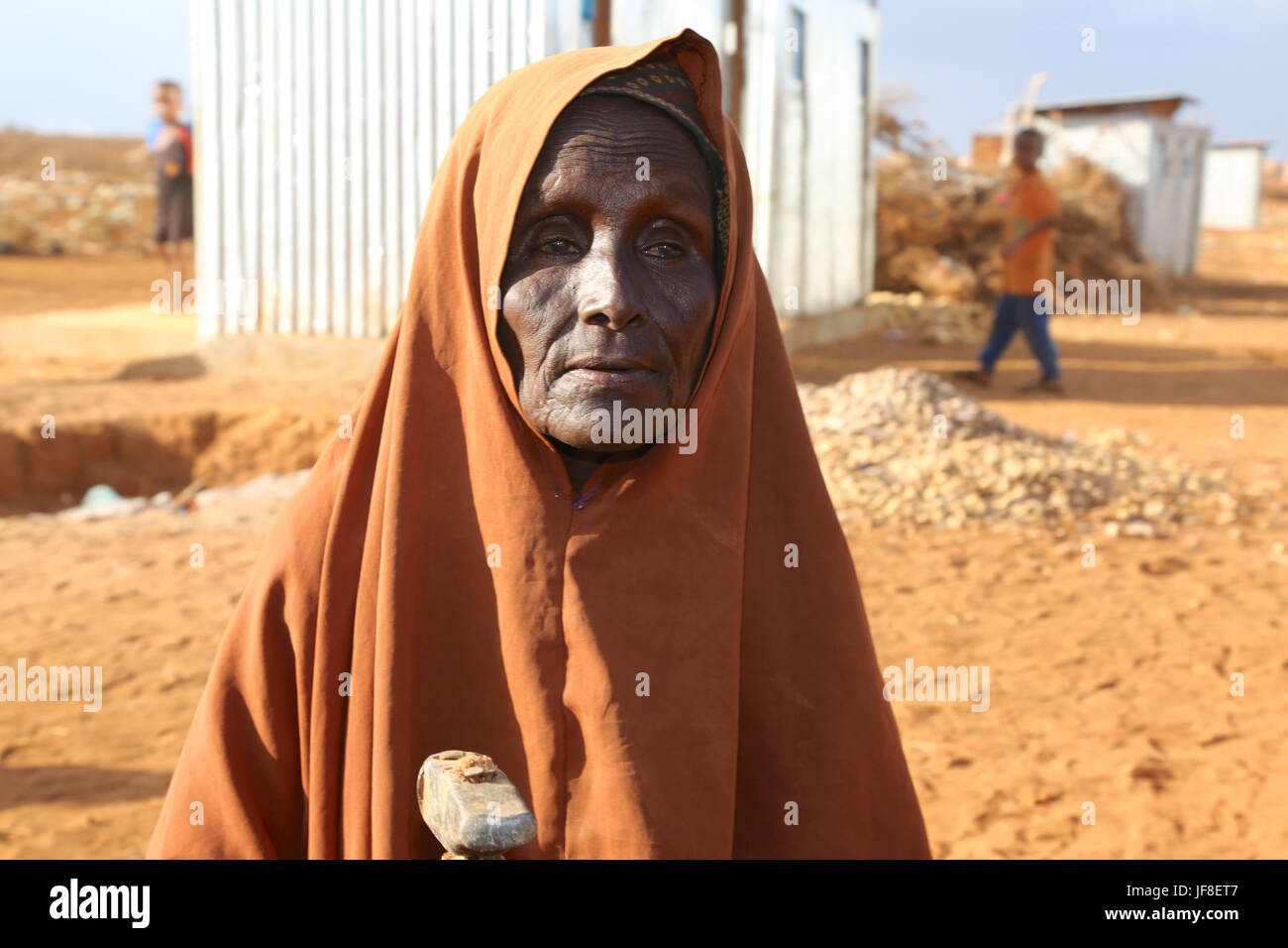 Khadija Ibrahim, un'anziana donna di sfollati si erge di fronte alla sua casa a Kormari campo per sfollati interni di Baidoa il 27 aprile 2017. Khadija produce la zavorra da pietre per sostenere la sua vita a Baidoa. Foto DELLE NAZIONI UNITE Foto Stock