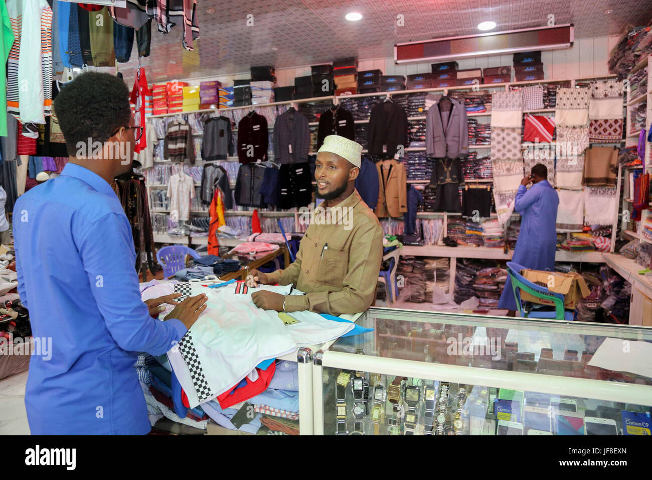 Un uomo la contrattazione con un negoziante mentre ad acquistare vestiti al mercato Suuqyare in Kismayo in preparazione per contrassegnare le celebrazioni Eid in Kismaayo il 23 giugno 2017. AMISOM foto Foto Stock