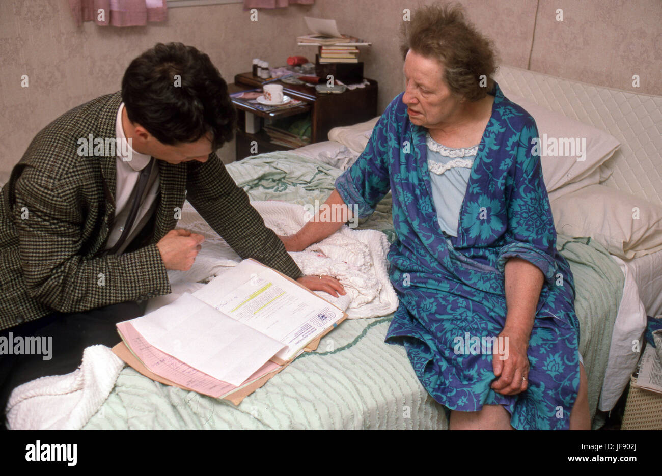 GP su una home visita il controllo su una vecchia donna in alloggi protetti Foto Stock