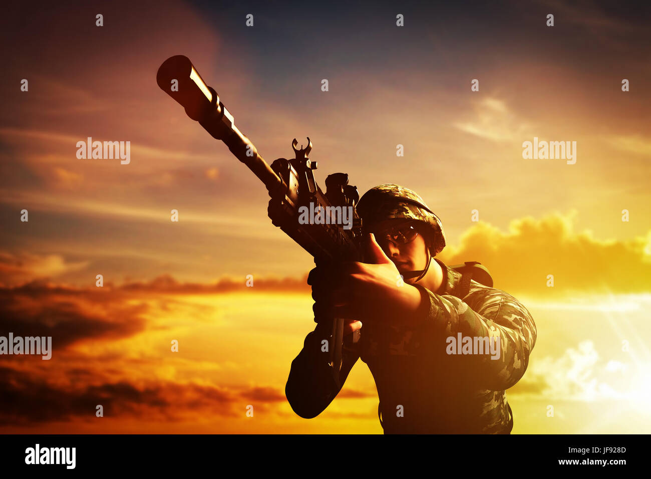 Soldato in combattimento a sparare con la sua arma, fucile al tramonto. La guerra, esercito, militare. Foto Stock