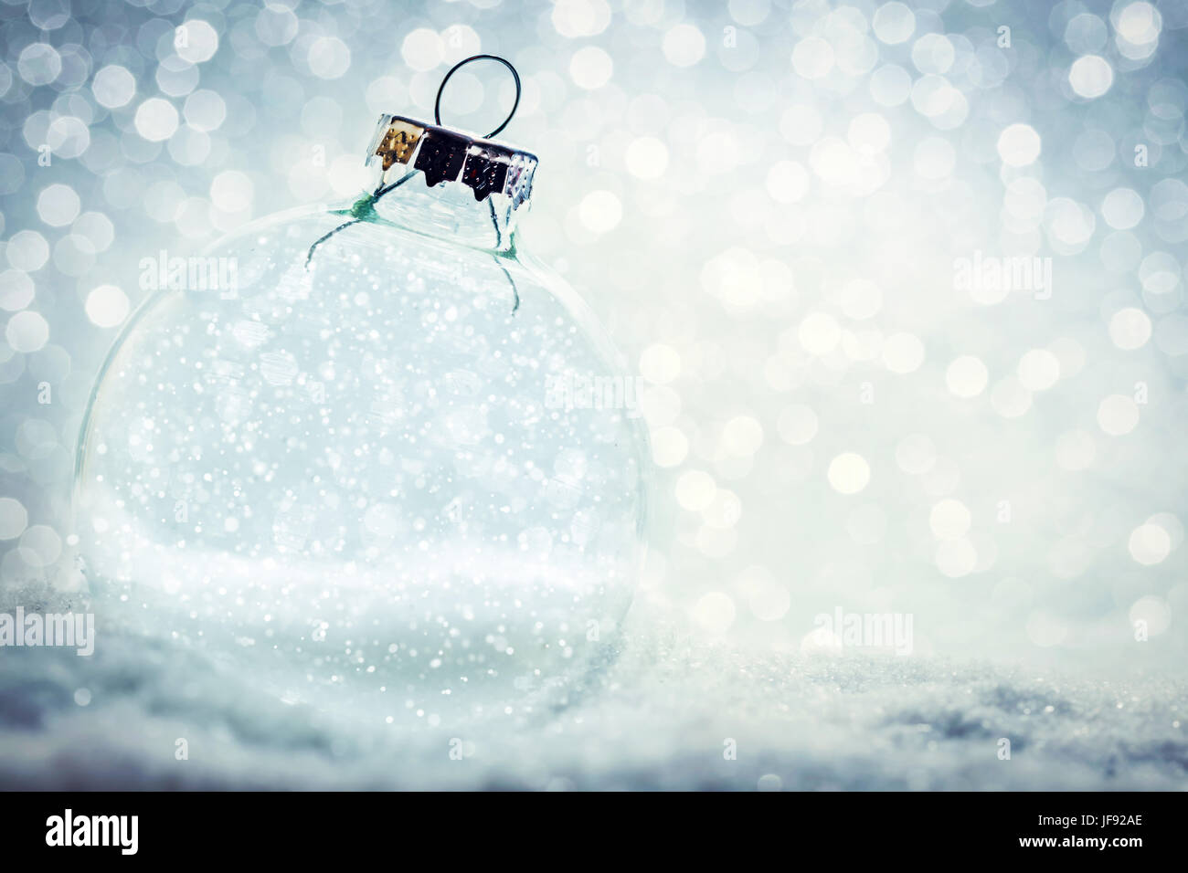 Il Natale di vetro con sfera trasparente, interno vuoto. Nevoso, glitter sfondo. Foto Stock