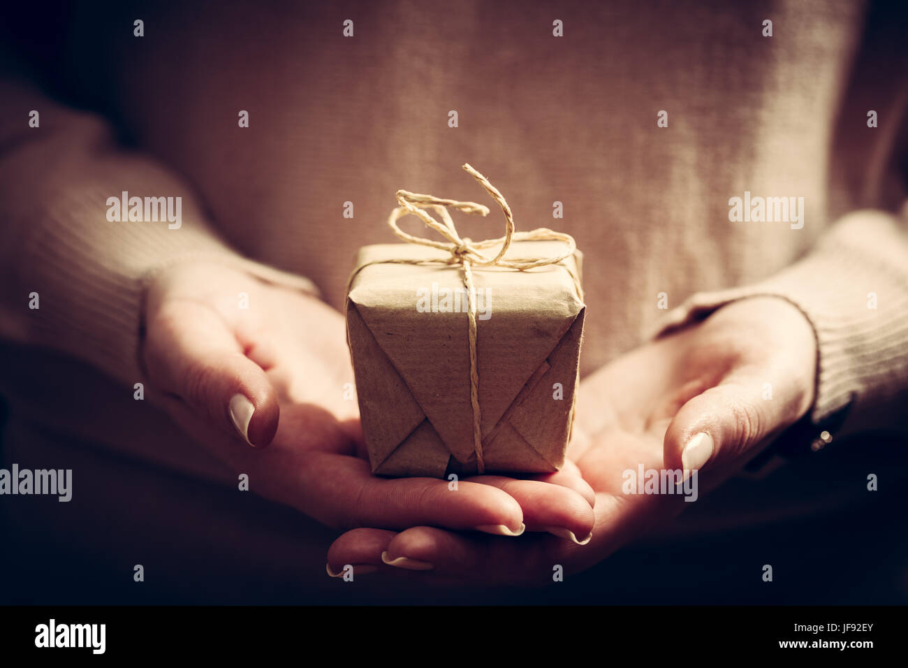 Fare un regalo a mano presente avvolto nella carta. Il tempo di Natale, vintage umore. Foto Stock