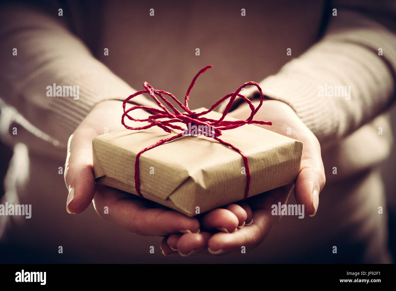 Fare un regalo a mano presente avvolto nella carta. Il tempo di Natale, vintage umore. Foto Stock