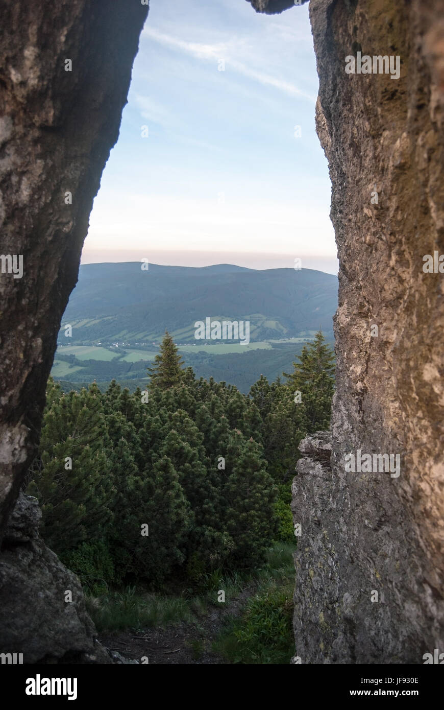 Vista attraverso il piccolo arco naturale su cervena hora hill in jeseniky montagne in Repubblica ceca con la valle con villaggi e rychlebske hory ra di montagna Foto Stock