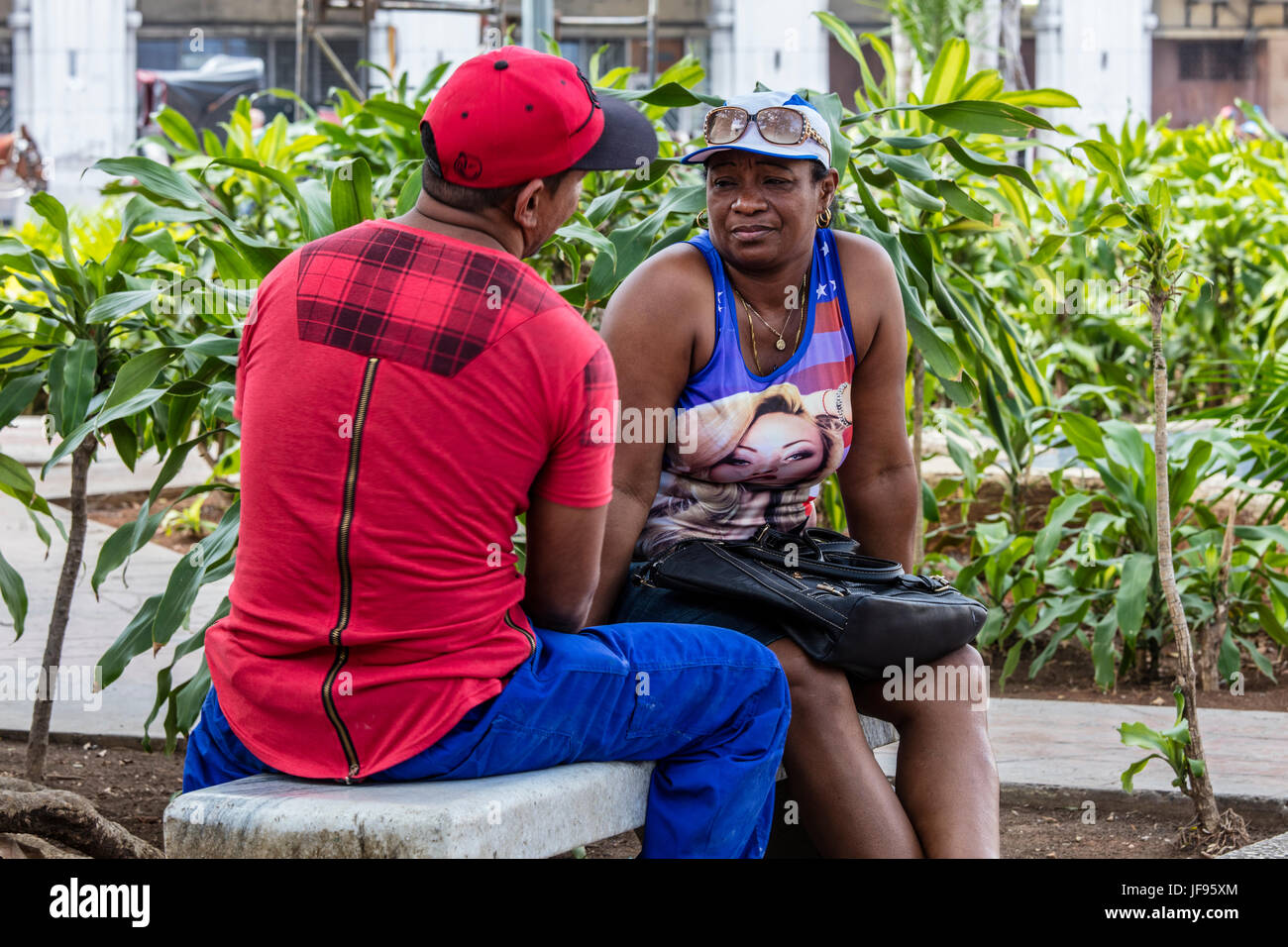 Un cubano giovane talk su una panchina nel Parque Central - Havana, Cuba Foto Stock