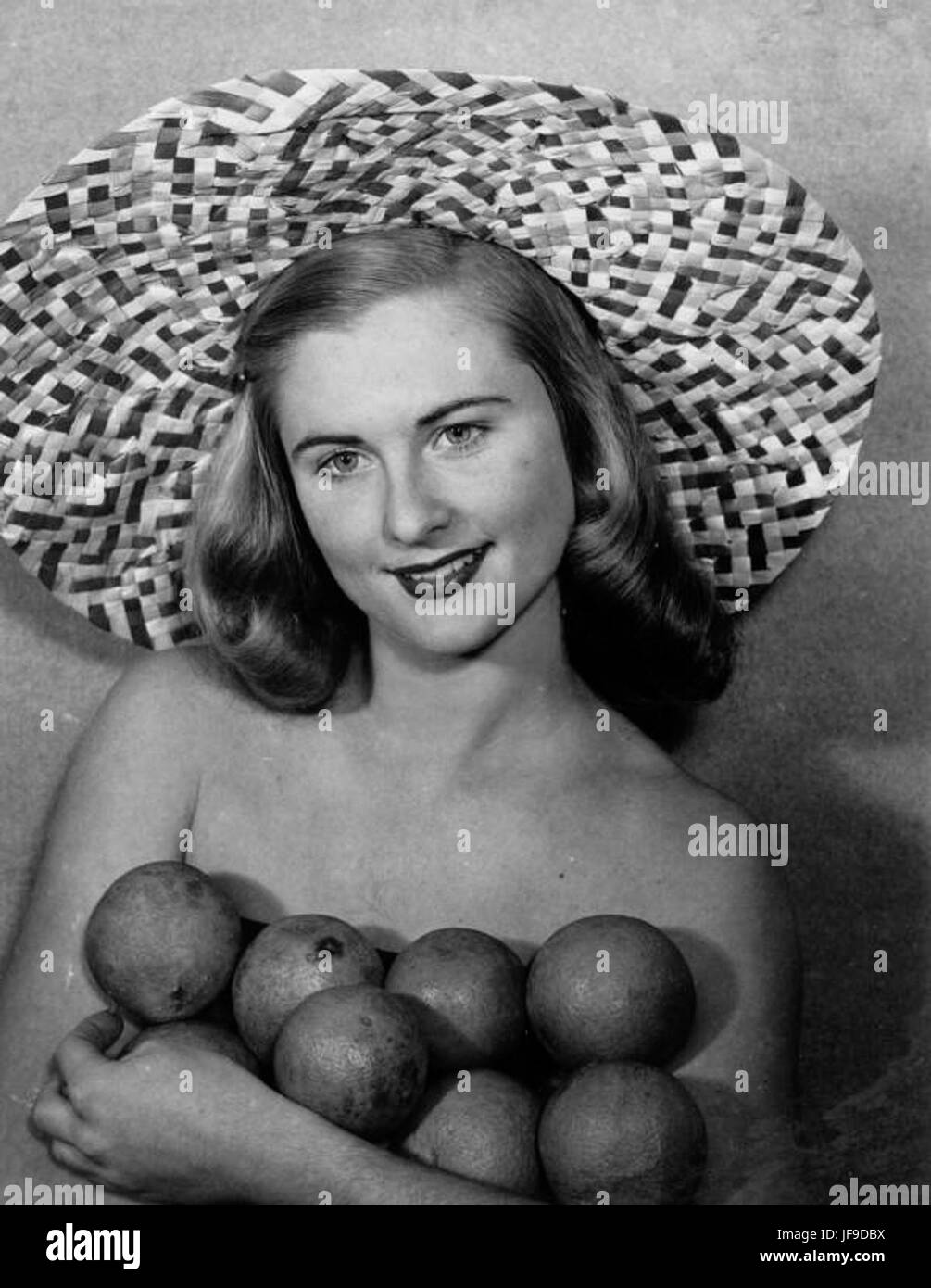 Evelyn Frankenberg, una foto d'epoca che la mostra indossando un grande cappello di paglia mentre tiene in mano le arance della Florida, simboleggiando il patrimonio agrumicolo dello stato. Foto Stock