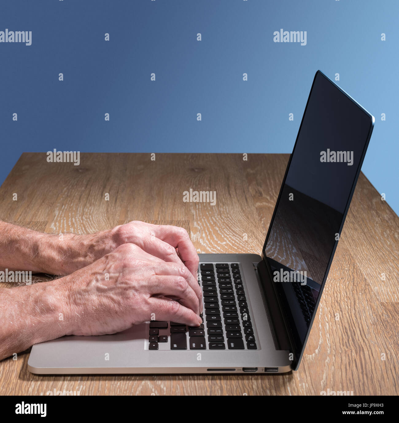 Senior adulto uomo toccare tipi su laptop Foto Stock