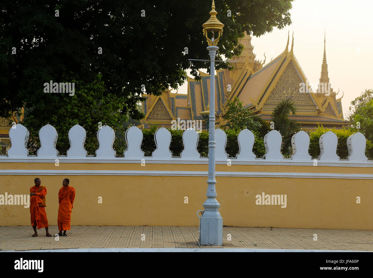 I monaci buddisti impegnati in varie attività nel e intorno al Palazzo Reale di Phnom Penh, Cambogia Foto Stock