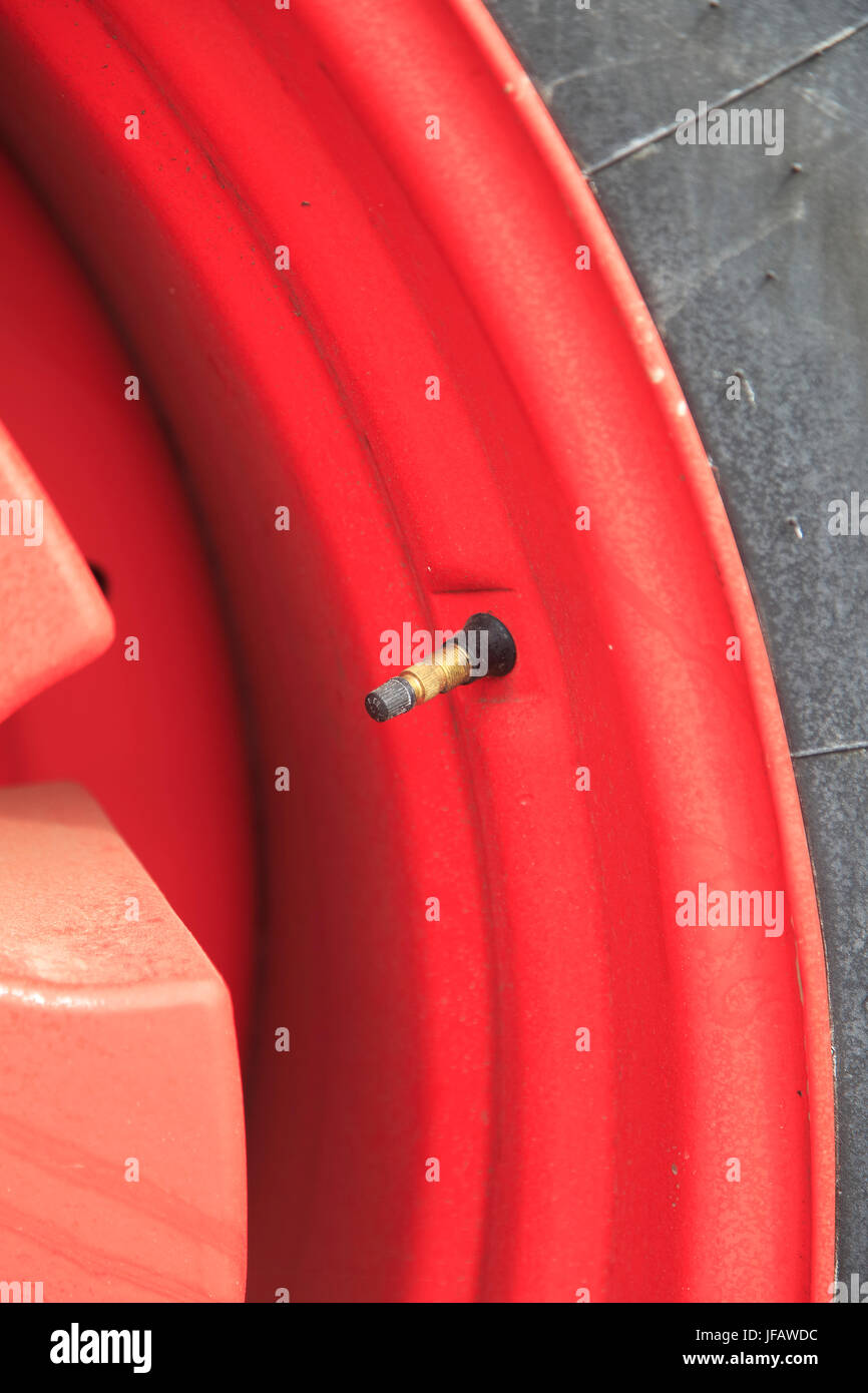 Close up di pneumatico della valvola aria su red ruota del trattore Foto Stock