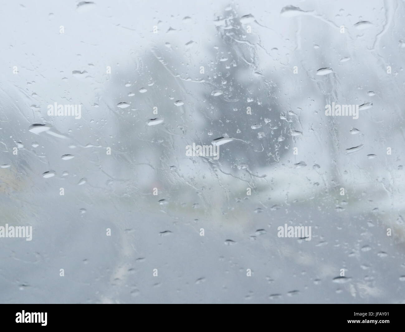Immagine sfocata del traffico vista attraverso un parabrezza di automobile coperti in caso di pioggia Foto Stock