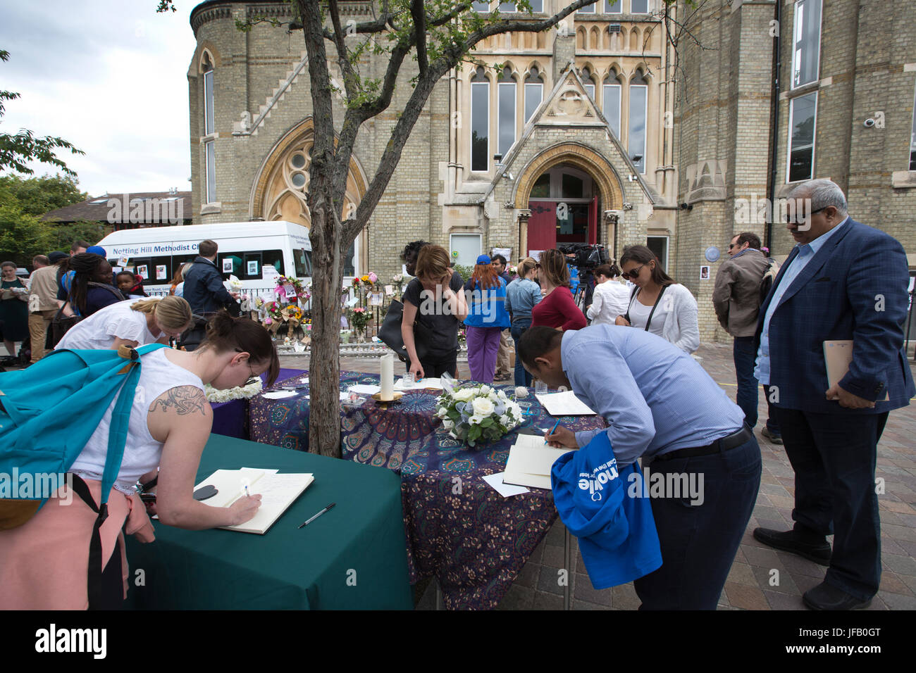 Le persone lasciano omaggi al di fuori di una chiesa locale per le vittime che hanno trovato la morte Grenfell Torre, 27 piani a torre fire in West London, England, Regno Unito Foto Stock