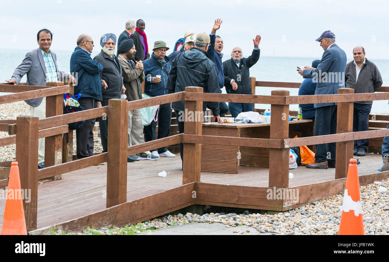 Groupd di anziani uomini indiano su una giornata fuori del Regno Unito, salutando la telecamera. Foto Stock