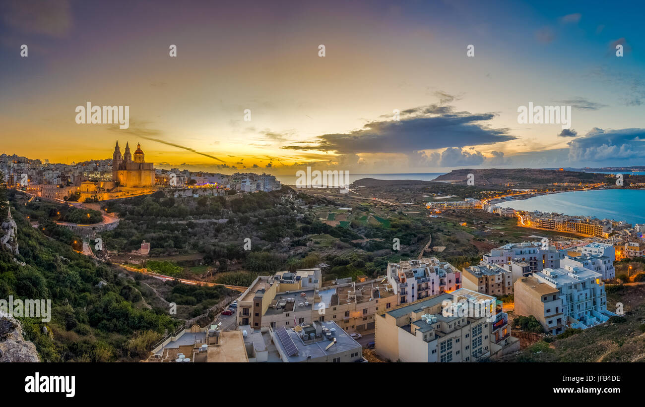 Il-Mellieha, Malta - splendida vista sullo skyline della città di Mellieha al tramonto con Parigi e Chiesa di Mellieha spiaggia presso lo sfondo con il cielo blu e Foto Stock