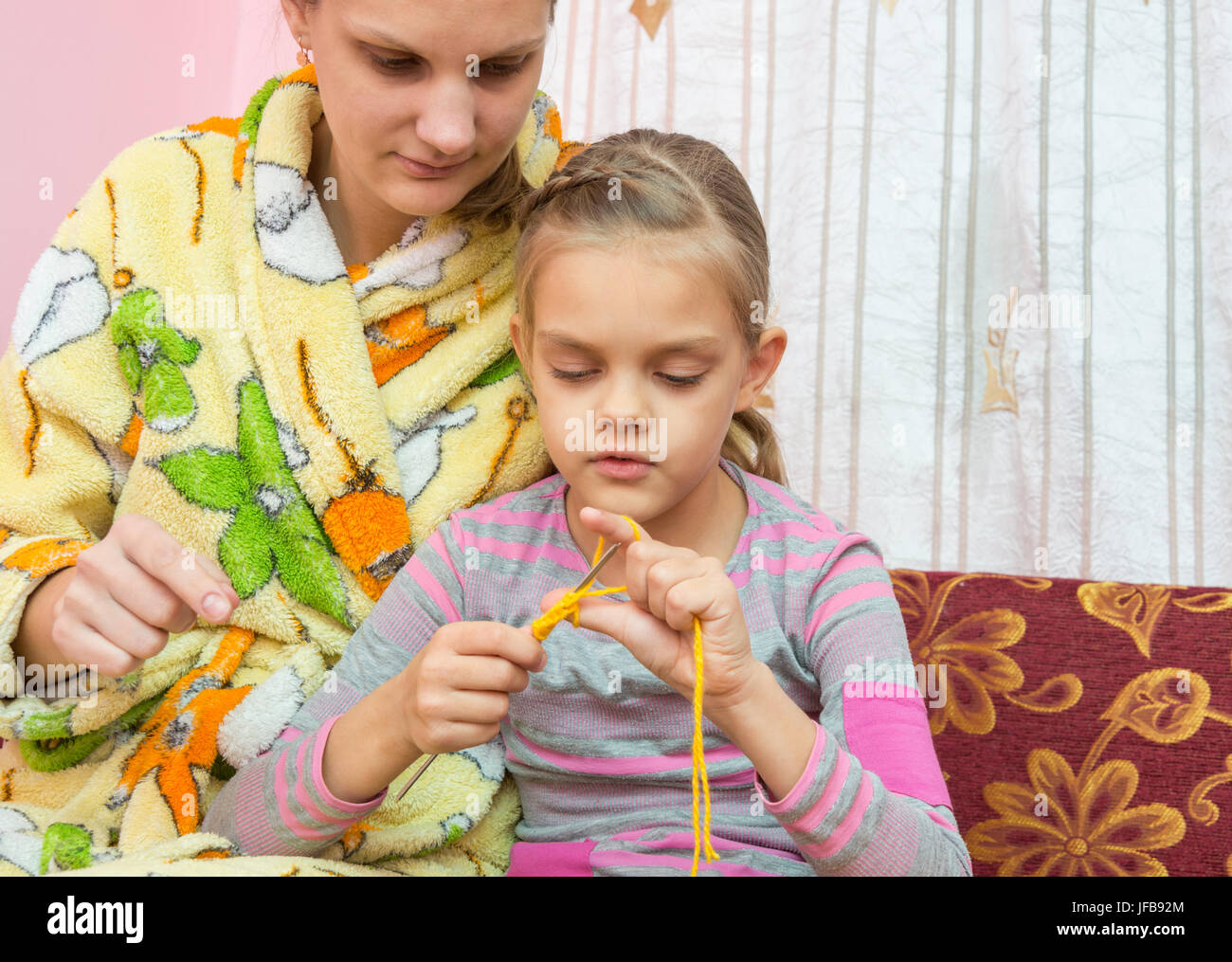 Mom mostra come imparare a lavorare a maglia Foto Stock