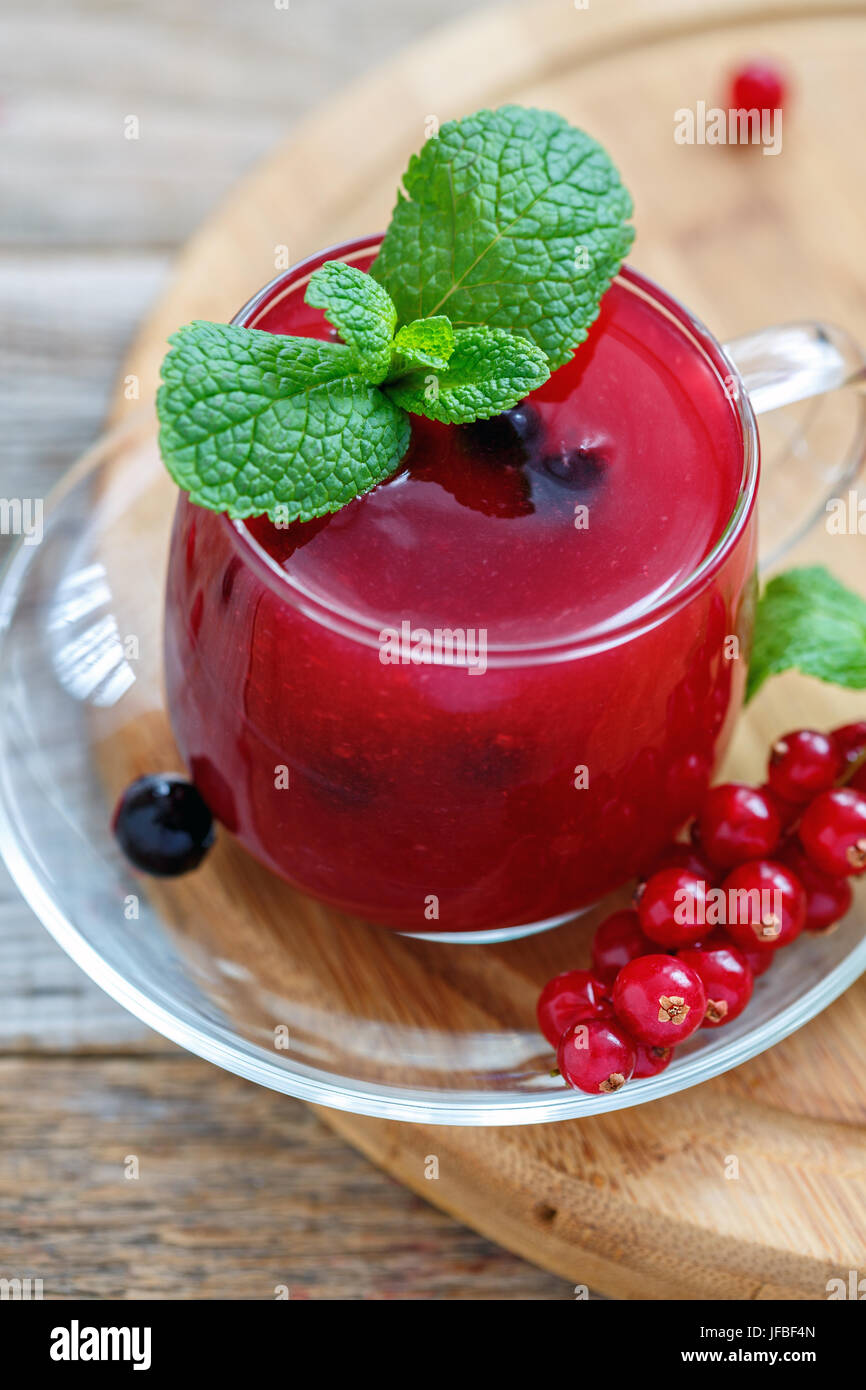 Il budino fatto di rosso e ribes in una ciotola di vetro di close-up. Foto Stock