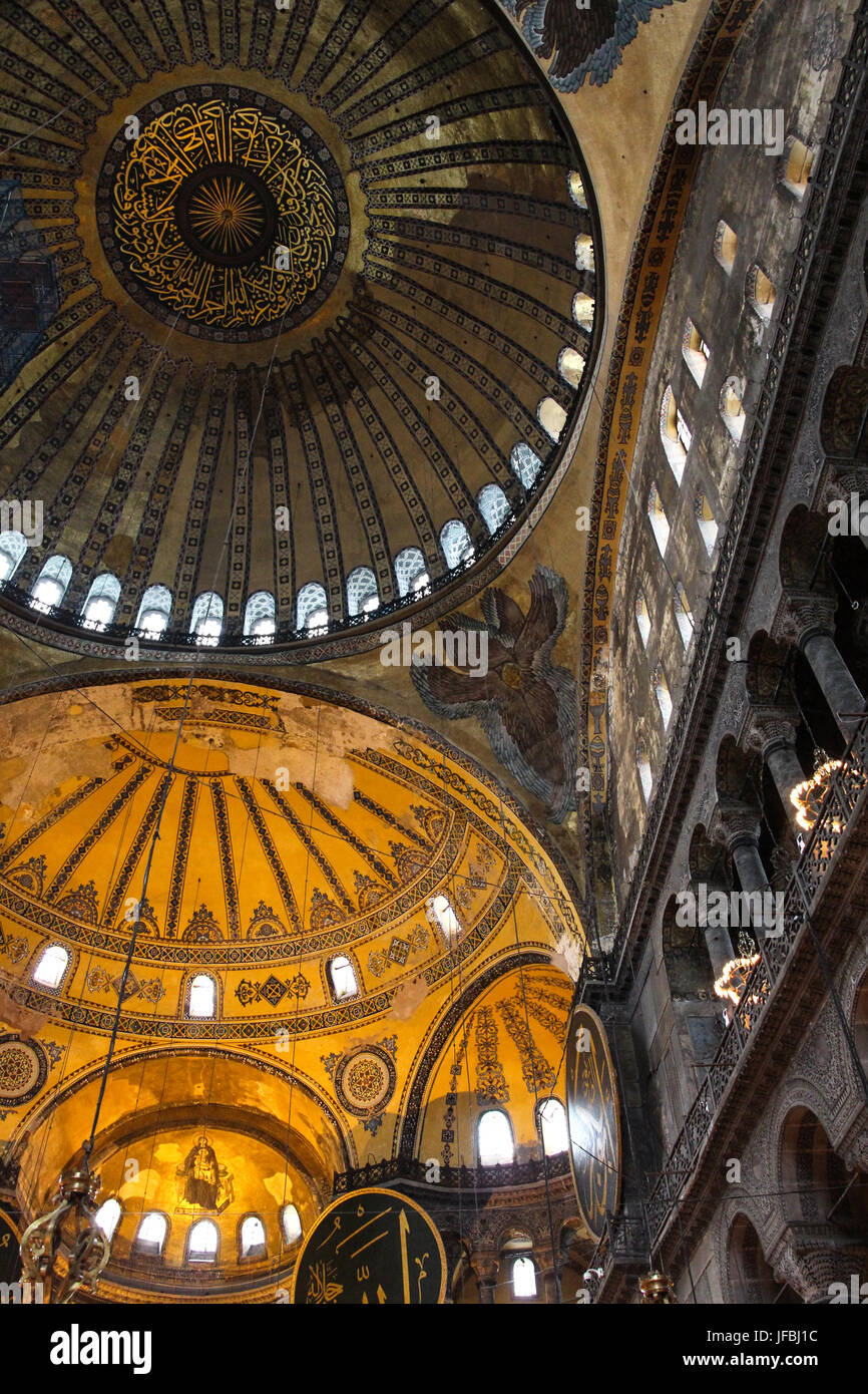 Guardando le magnifiche cupole a soffitto nell'Hagia Sophia a Istanbul, Turchia. vernice gialla, decorazioni, windows e cascata di cupole e colonne. Foto Stock