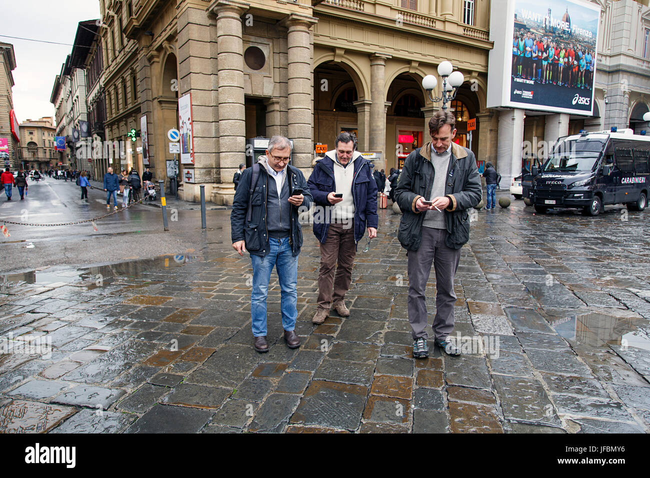 Tre uomini guardando i loro smart phone Foto Stock