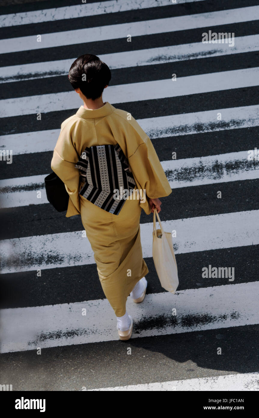 Giovane donna wearimg un kimono, su un attraversamento pedonale. Dalla testa Foto Stock